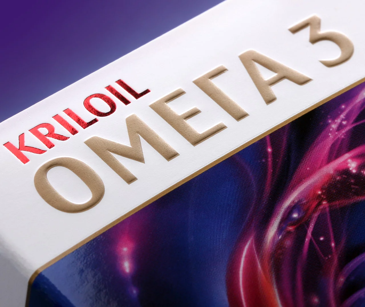 Крупный план упаковки продукта с надписью KRILOIL ОМЕГА 3, выполненной жирным шрифтом красного и бежевого цвета, с частью абстрактного красочного дизайна и брендом Soldis, видимым под текстом.