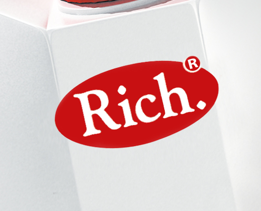 Красный овальный логотип со словом «Rich», написанным жирным белым шрифтом, и символом зарегистрированной торговой марки, расположенный на углу белой коробки или контейнера Soldis.