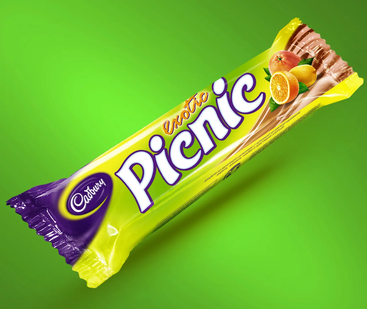 Шоколадный батончик Cadbury Exotic Picnic в желто-фиолетовой упаковке с изображениями цитрусовых, размещенными на ярко-зеленом фоне от Soldis.
