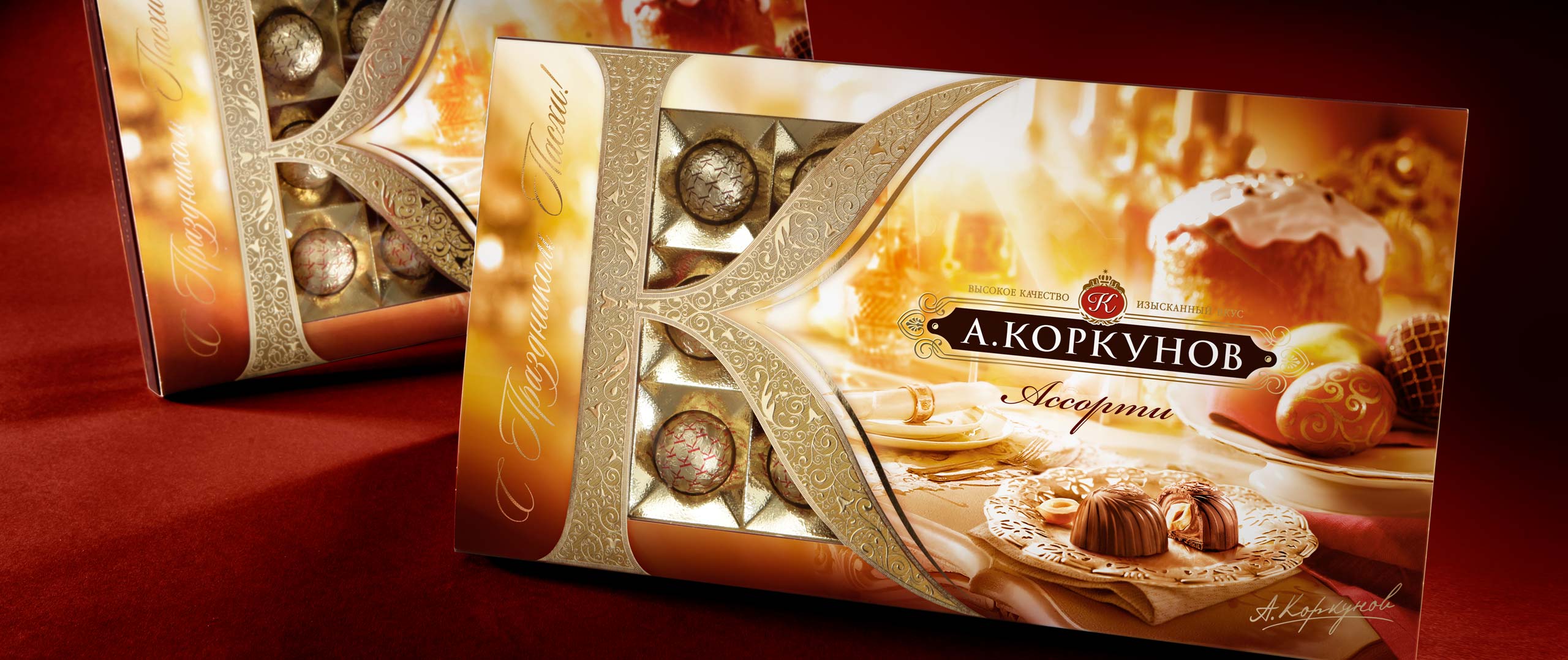 Показана декоративная коробка с набором шоколадных конфет A. Korkunov, отличающаяся элегантной упаковкой золотого и коричневого цветов с декоративными узорами. Частично открытая коробка показывает различные шоколадные кусочки внутри, подчеркивая качество, которое представляет Soldis.