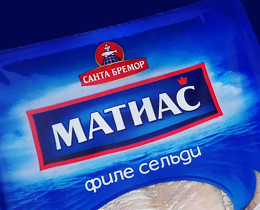 Синяя упаковка с надписью Санта МАТИАС «Филе сельди» с изображением океанских волн, логотипом Soldis и частью маринованного филе сельди, видимой внутри. Текст на русском языке.