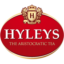 Красно-золотой логотип чая Hyleys с короной и щитом, буквой H над словами Hyleys The Aristocratic Tea, выполненными белым и золотым текстом на красном овальном фоне, разработанный Soldis.